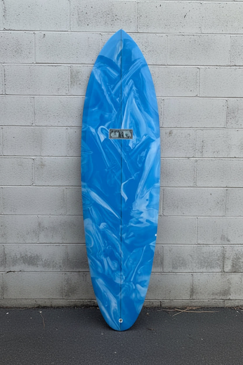 A blue and white marbled surfboard by mccallum twin fin